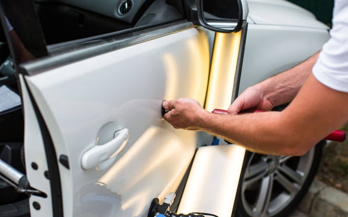 West Delray Collision Center photo of mechanic performing paintless dent repair on a car in Boynton Beach, FL West Delray Collision Center photo of mechanic performing paintless dent repair on a car in Boynton Beach, FL